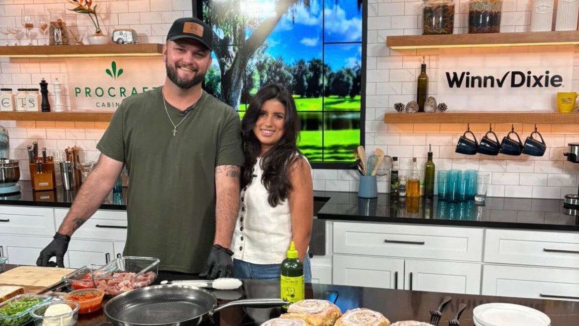 Jon and Naomi standing behind their House of Trinity Baking Co. booth at a farmers market